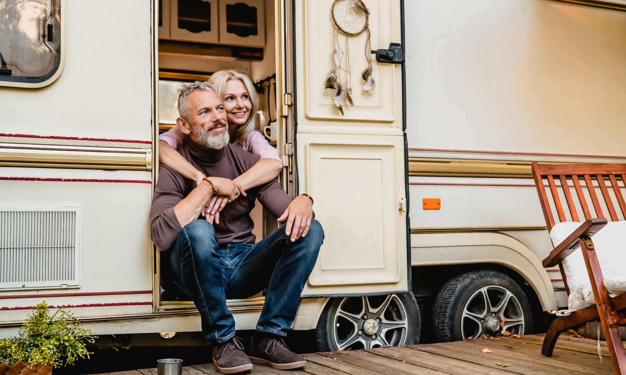 A man and woman sitting on the steps of an rv.