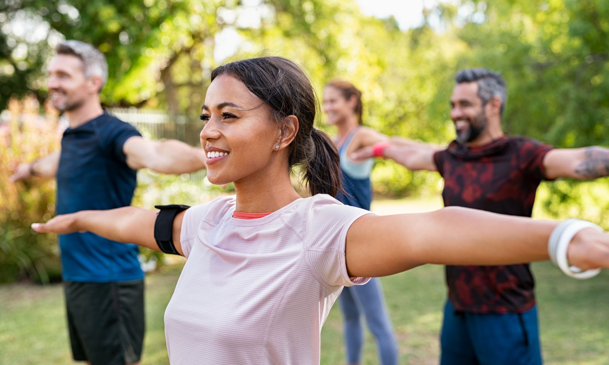 A group of people doing different exercises in the park.