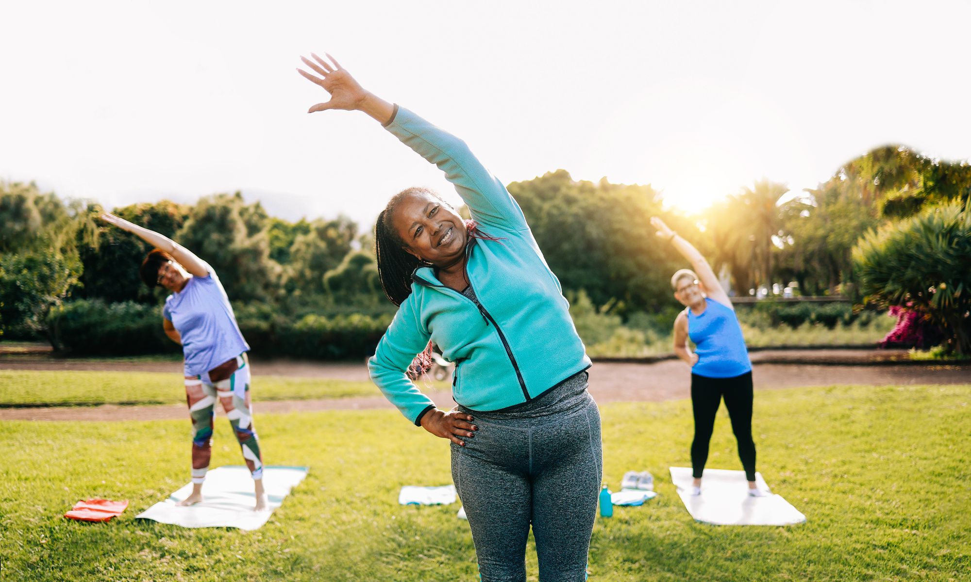 A group of people doing different exercises in the park.