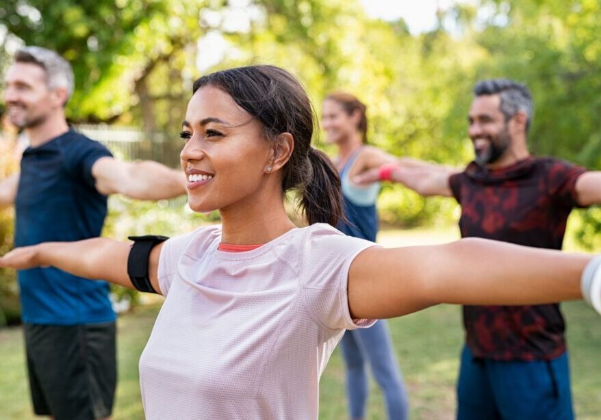 A group of people doing different exercises in the park.