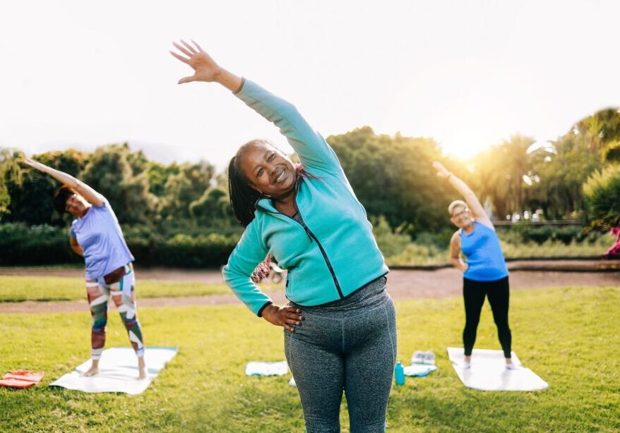 A group of people doing different exercises in the park.